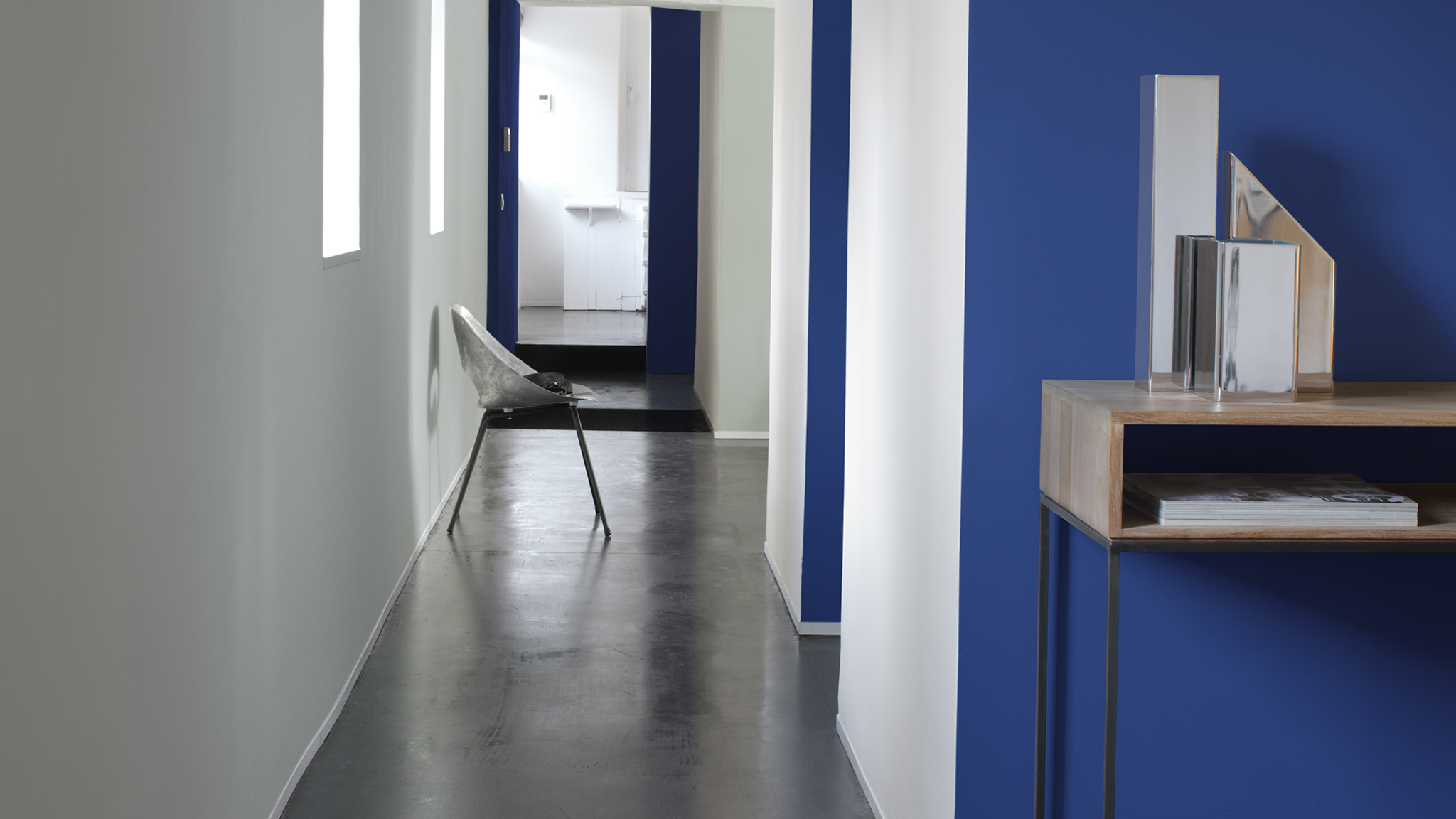 Creeer ruimte door een optische illusie Als je licht houtwerk combineert met donkere muren, dan maak je de woning ruimtelijker.