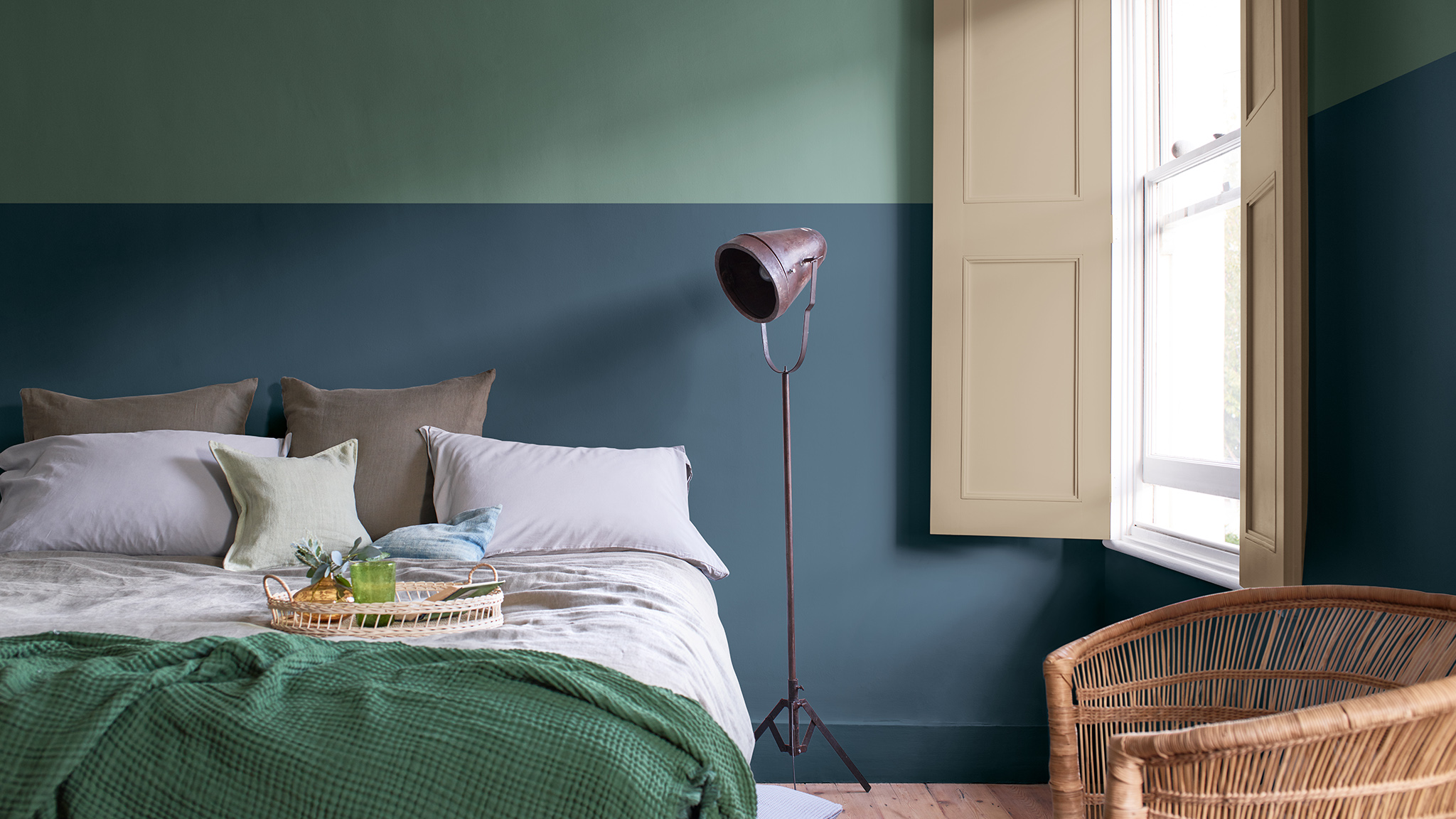 Slaapkamer met een tweekleurige muur in diep blauw en saliegroen Slaapkamer met een tweekleurige muur in diep blauw en saliegroen