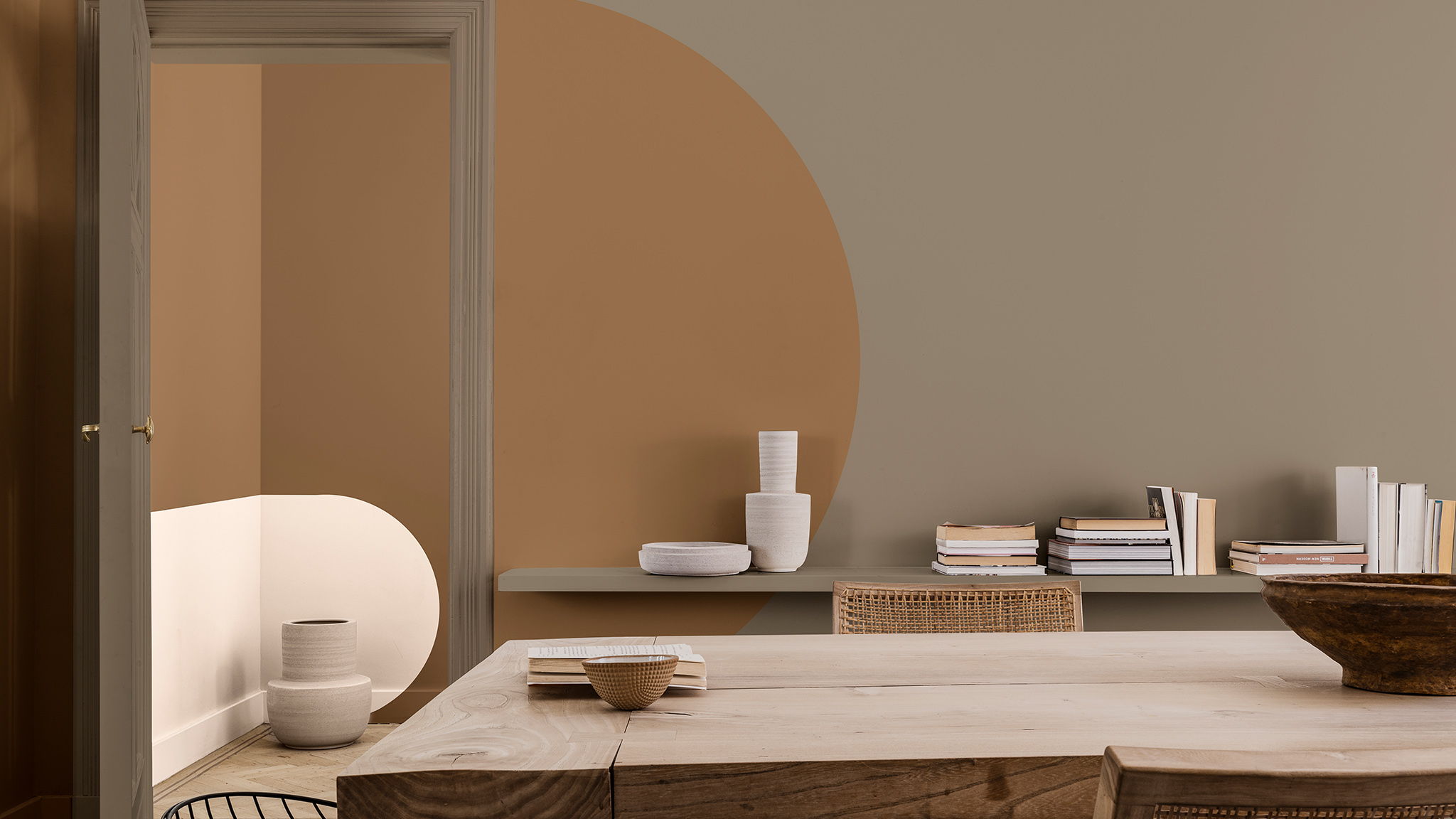 Crèmekleurige en bruine bogen op muur met eettafel en stoelen op de voorgrond Crèmekleurige en bruine bogen op muur met eettafel en stoelen op de voorgrond