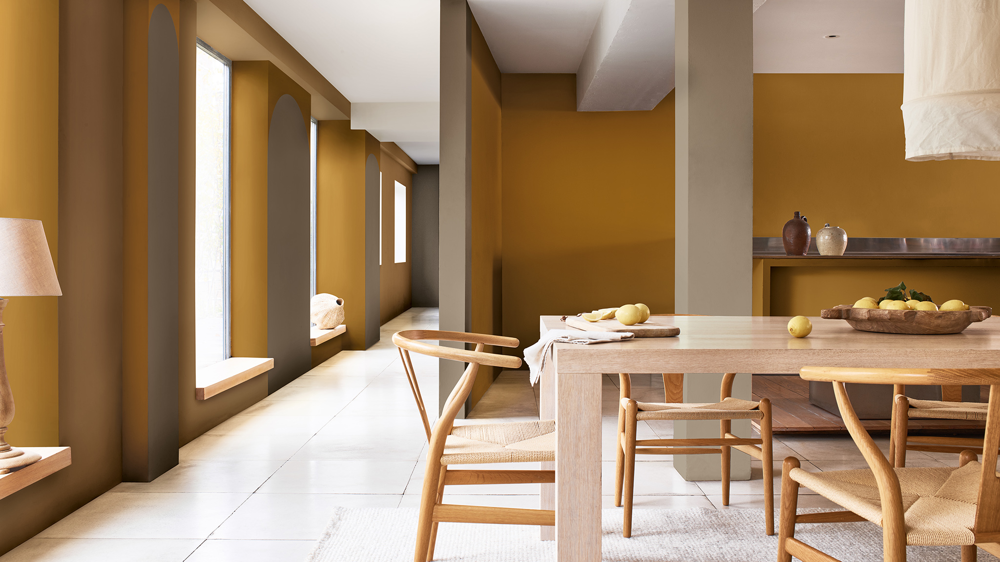 Open eetkamer met houten tafel en hoge ramen aan de linkerkant Open eetkamer met houten tafel en hoge ramen aan de linkerkant