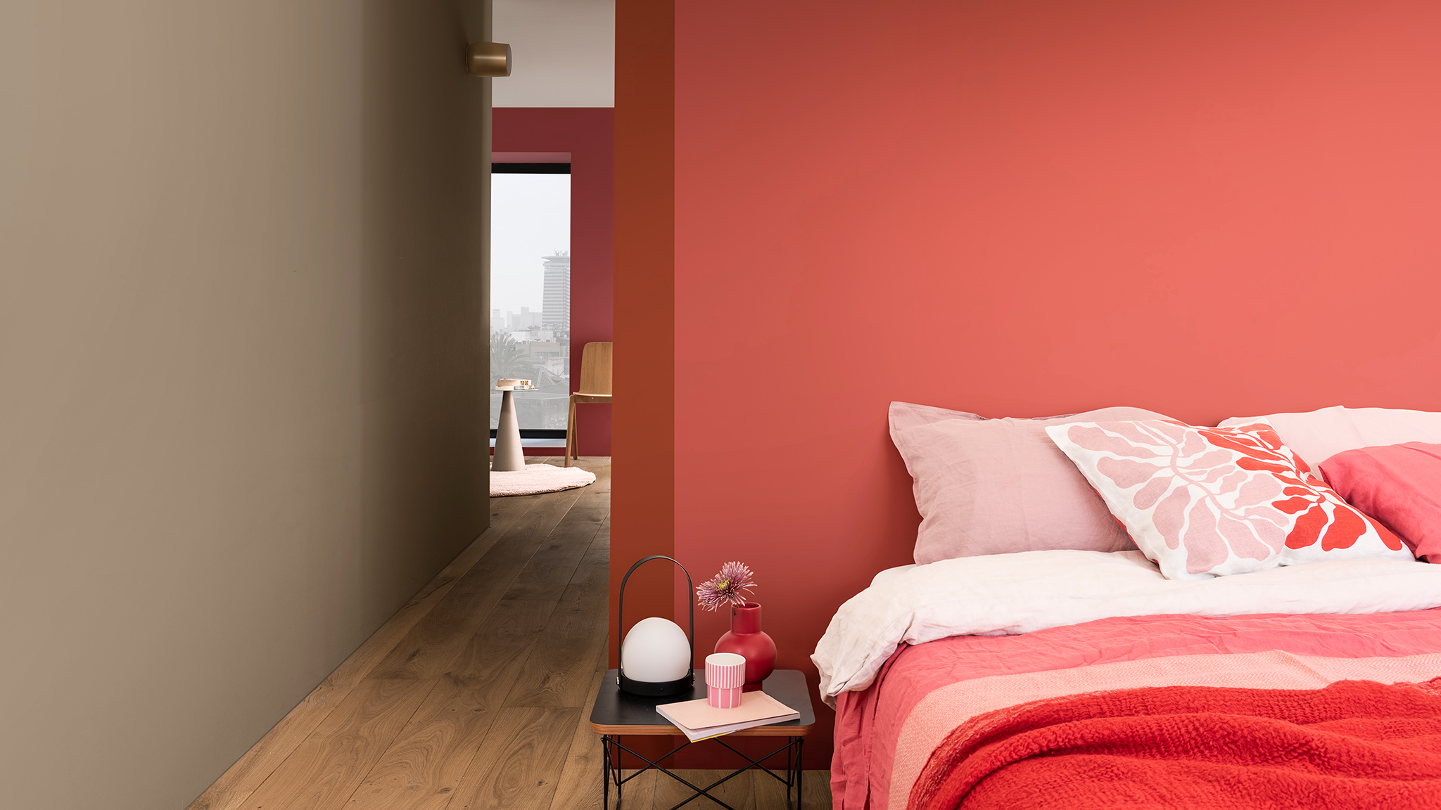 Bed met roze bloemetjeskussen tegen een dieproze muur Bed met roze bloemetjeskussen tegen een dieproze muur